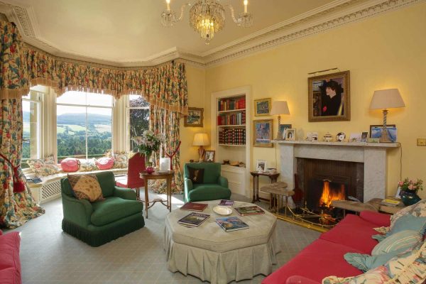 A colour image of the lounge with roaring fire at Edradynate Country House and Sporting Estate Scotland. Edradynate is available for rent, shoot days, fishing and family holidays on a catered or self catered basis.