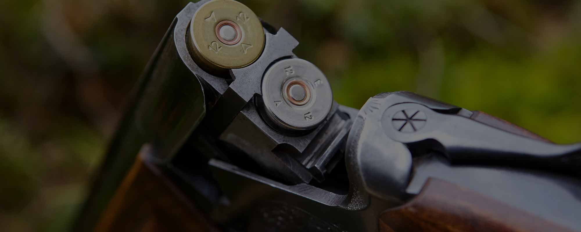 A Photograph of an opened wooden double-barreled hunting gun with two cartridges at a shoot at Edradynate Estate - Shooting Holidays in Scotland - Edradynate Estate, Luxury Country House and Sporting Estate, Perthshire