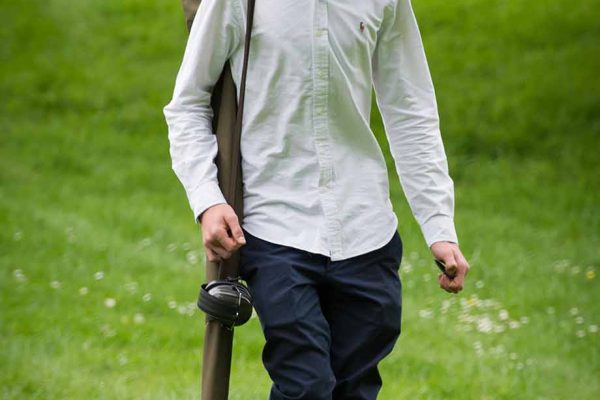 A COLOUR IMAGE OF A YOUNG GUEST WALKING AND CARRYING A GUN AT EDRADYNATE ESTATE clay pigeon shoot day - Edradynate Estate, Perthshire - Luxury Country House and Sporting Estate for Rent in Scotland